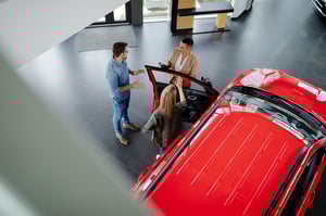 Clients qui regardent une voiture de luxe dans une concession