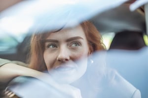 Femme regardant par la fenêtre d'une voiture