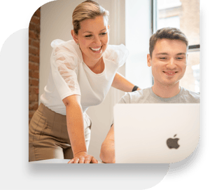 Two Kimoby employees collaborating on a computer or laptop.